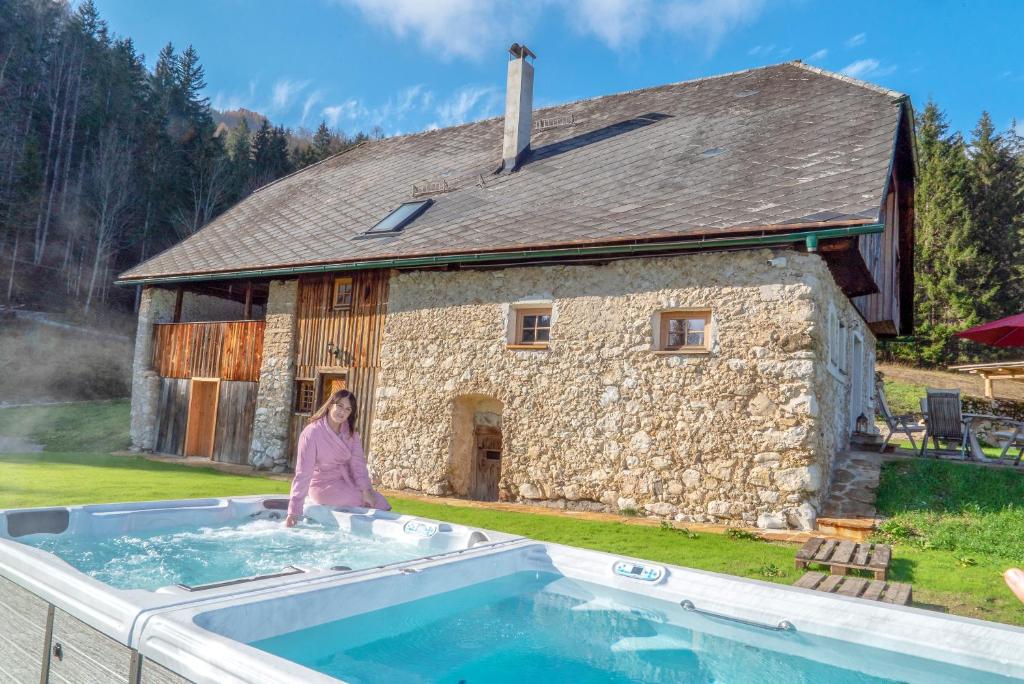 a woman standing in a pool in front of a building at Obiralmhütte Mosgan in Bad Eisenkappel