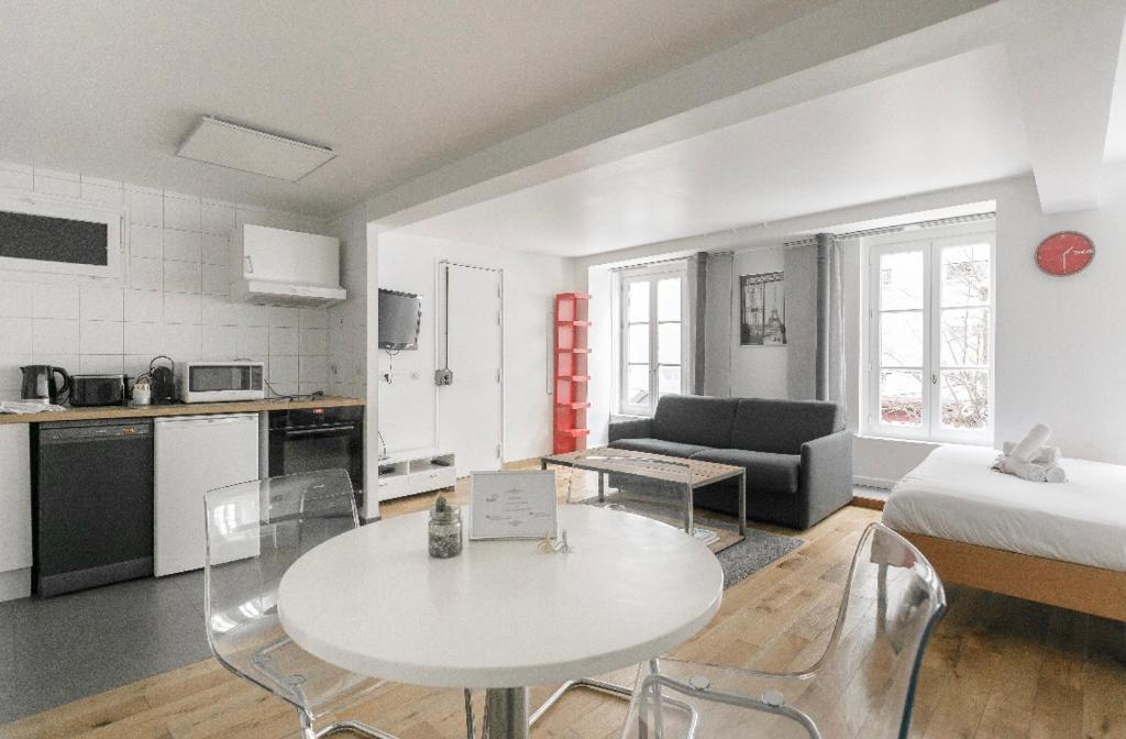 パリにある50m2 rue rambuteau/Pompidou/Marais/Hôtel de Villeのテーブルとベッド1台付きの部屋、キッチンが備わるアパートメントです。