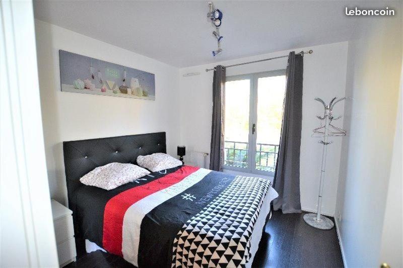 1 dormitorio con cama y ventana en Chambre d'Hôtes Proche de Disneyland et Pas Loin de Paris, en Bussy-Saint-Georges