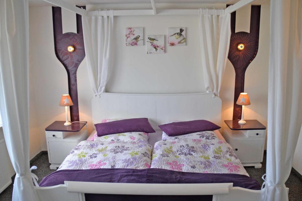 1 dormitorio con 1 cama blanca y 2 mesitas de noche en Ferienhaus _Hasenland_, en Kerkwitz