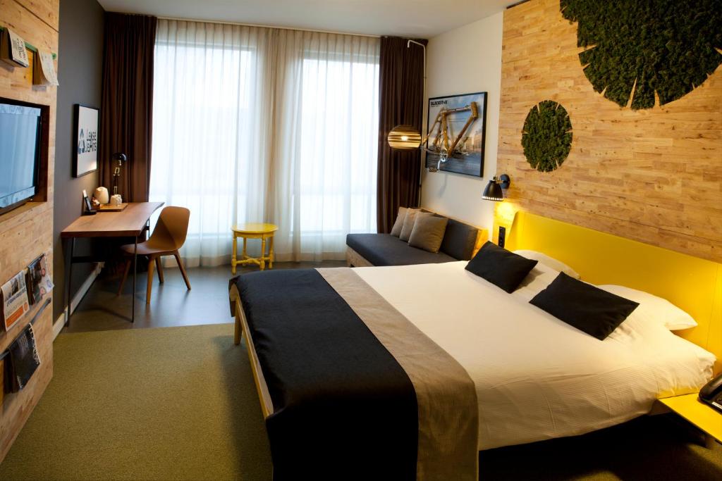 a hotel room with a large bed and a desk at Skotel Amsterdam, Hotelschool The Hague in Amsterdam