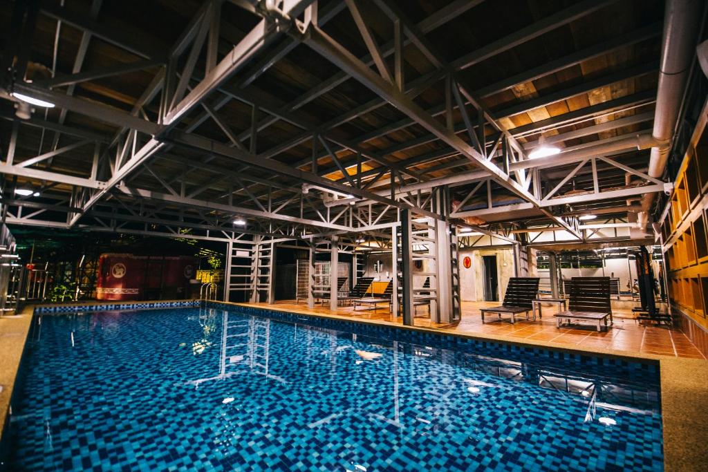 una grande piscina con acqua blu in un edificio di Rick Resort Teluk Intan a Teluk Intan