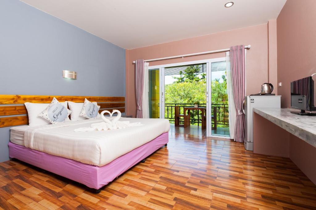 - une chambre avec un grand lit et un balcon dans l'établissement Greenery Resort Koh Tao, à Koh Tao