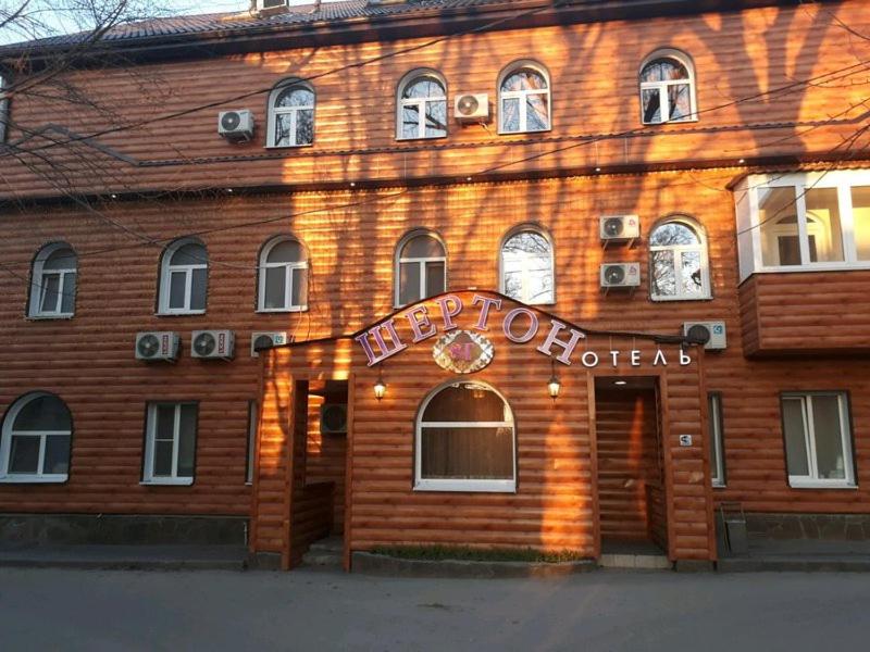 a brown building with a sign on it at Sherton Hotel in Rostov on Don