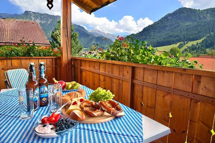 een tafel met een bord eten en flessen wijn bij Landhaus Carolin Göhl in Bad Hindelang