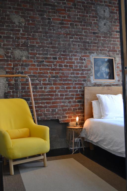 a bedroom with a bed and a yellow chair at Chambre d&#39;hôtes la Teinturerie in Roubaix