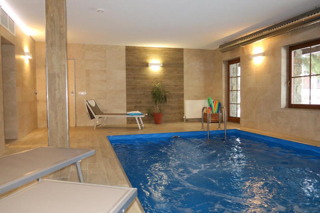 una piscina en una habitación con una gran piscina azul en Chalet Hřebenka en Harrachov