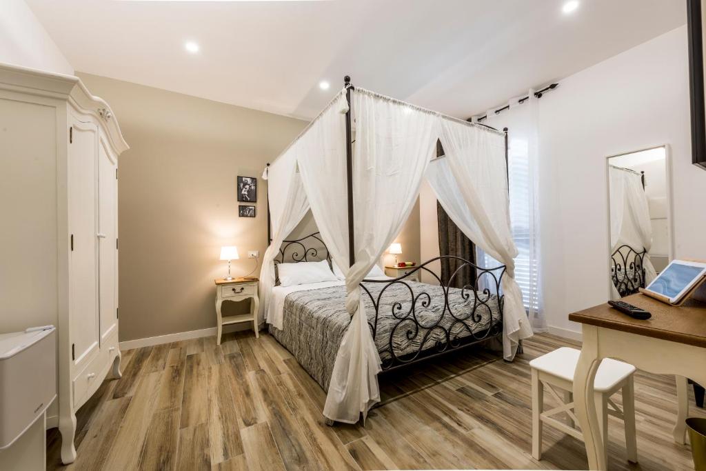 um quarto com uma cama de dossel e uma secretária em Il Parco dei Poeti B&B em Cellino Attanasio