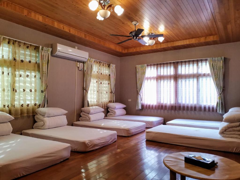 a room with three beds and a table at Sitou Peach Villa B&amp;B in Lugu Lake