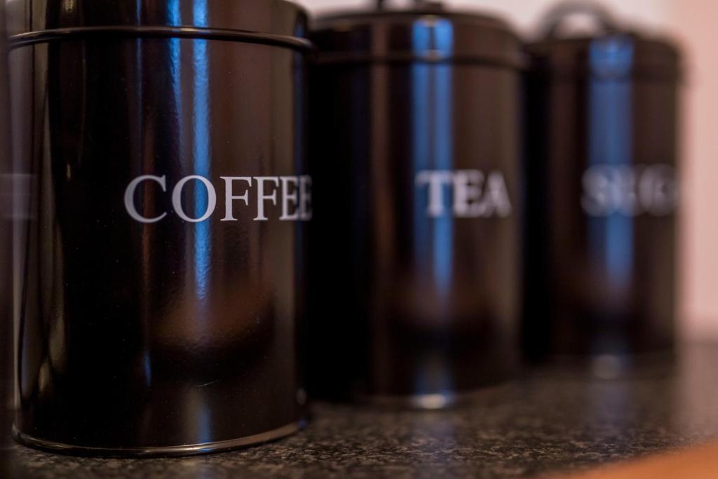 una fila di tazze di caffè, appoggiate su un bancone di D13 Self Catering TownHouse a Dublino