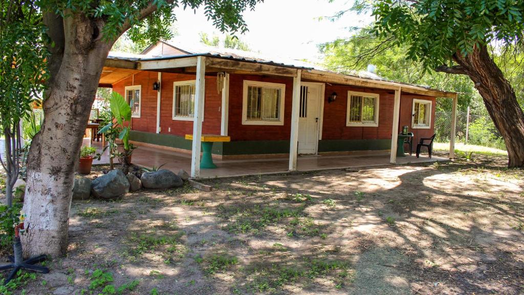 ein kleines Haus mit einer Veranda und einem Baum in der Unterkunft Catamarca Hospedaje Star in San Isidro