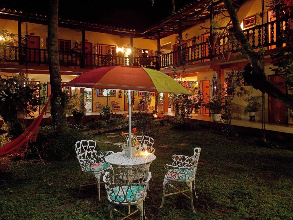 a table and chairs with an umbrella in a yard at Portal dos Borbas in Abraão