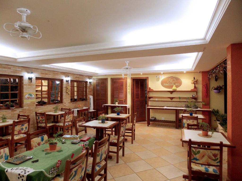 a restaurant with wooden tables and a piano at Portal dos Borbas in Abraão