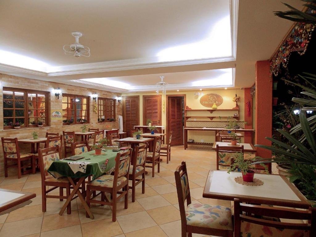 a restaurant with tables and chairs and a piano at Portal dos Borbas in Abraão