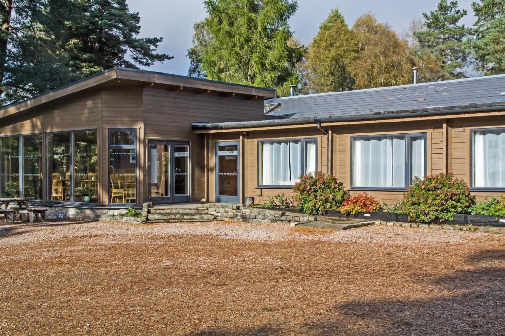 una casa de madera con muchas ventanas en Old Pines Hotel And Restaurant en Spean Bridge