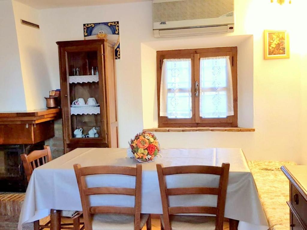 una sala da pranzo con tavolo, sedie e finestra di Belvilla by OYO Casa Le Meridiane a Chiusdino