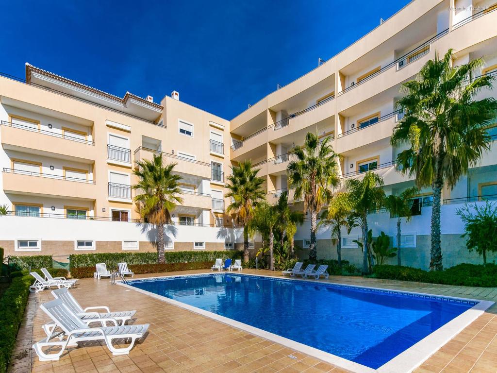 ラゴスにあるA05 - Luxury 1 Bed Fully Equipped with Poolのヤシの木とスイミングプールのある大きなアパートメントです。