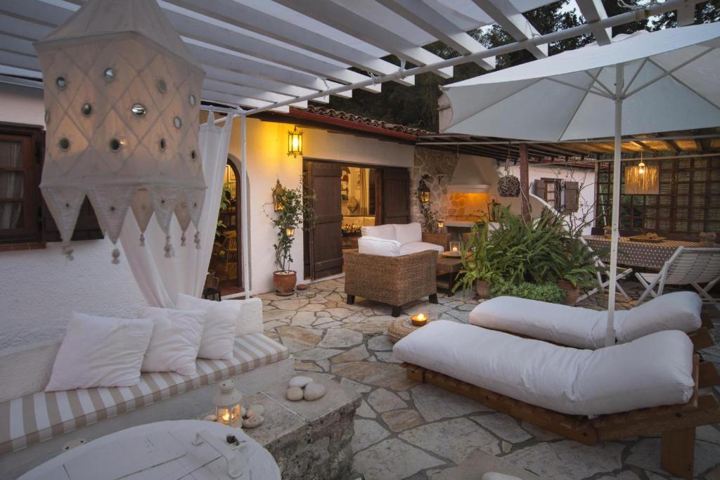 a patio with white couches and an umbrella at Tritonia in Gaios