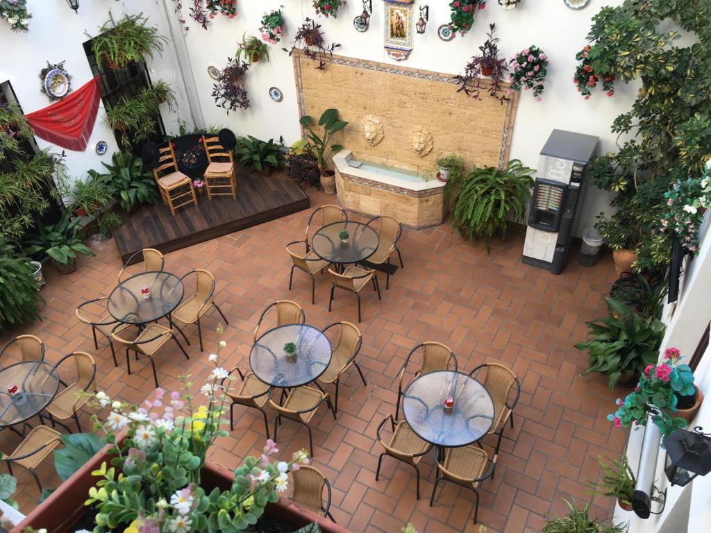 - une vue sur la terrasse dotée de tables et de chaises dans l'établissement Hotel de Los Faroles, à Cordoue