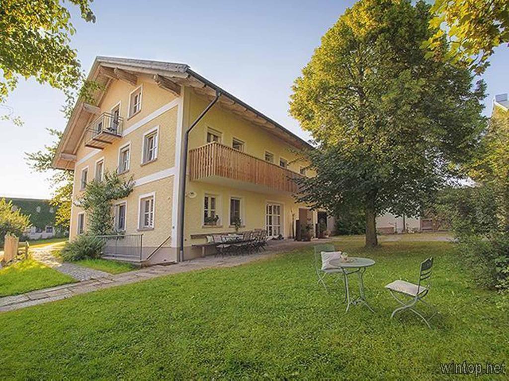 ein großes gelbes Haus mit einem Tisch und Stühlen im Hof in der Unterkunft FrongaHOF in Waldkirchen