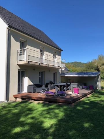 a large house with a large deck in the yard at Villa MARIA in Chambon-sur-Lac