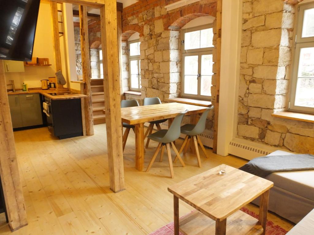 a living room with a wooden table and chairs at "Kutscherstube" - Hammergut Neidberg in Bielatal