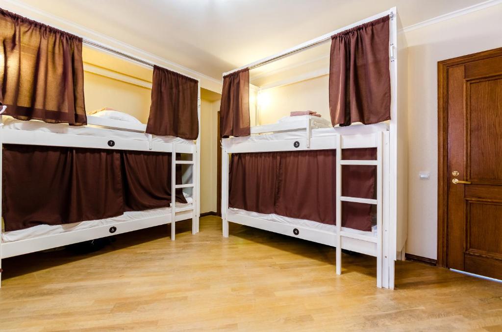 Ce dortoir comprend 2 lits superposés et une porte. dans l'établissement Sun City Hostel 3, à Kiev