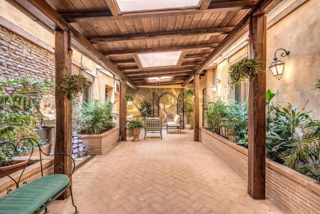 un corridoio interno con piante e soffitto di Residenza San Calisto a Roma