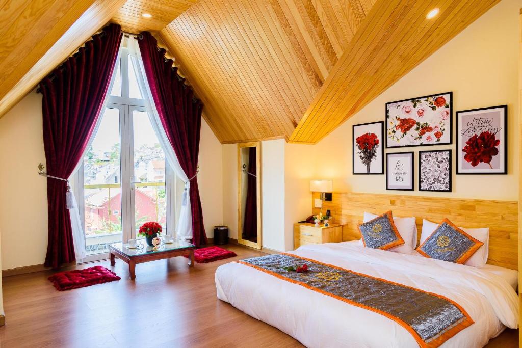 - une chambre avec un grand lit et une grande fenêtre dans l'établissement VF Hotel Dalat, à Đà Lạt
