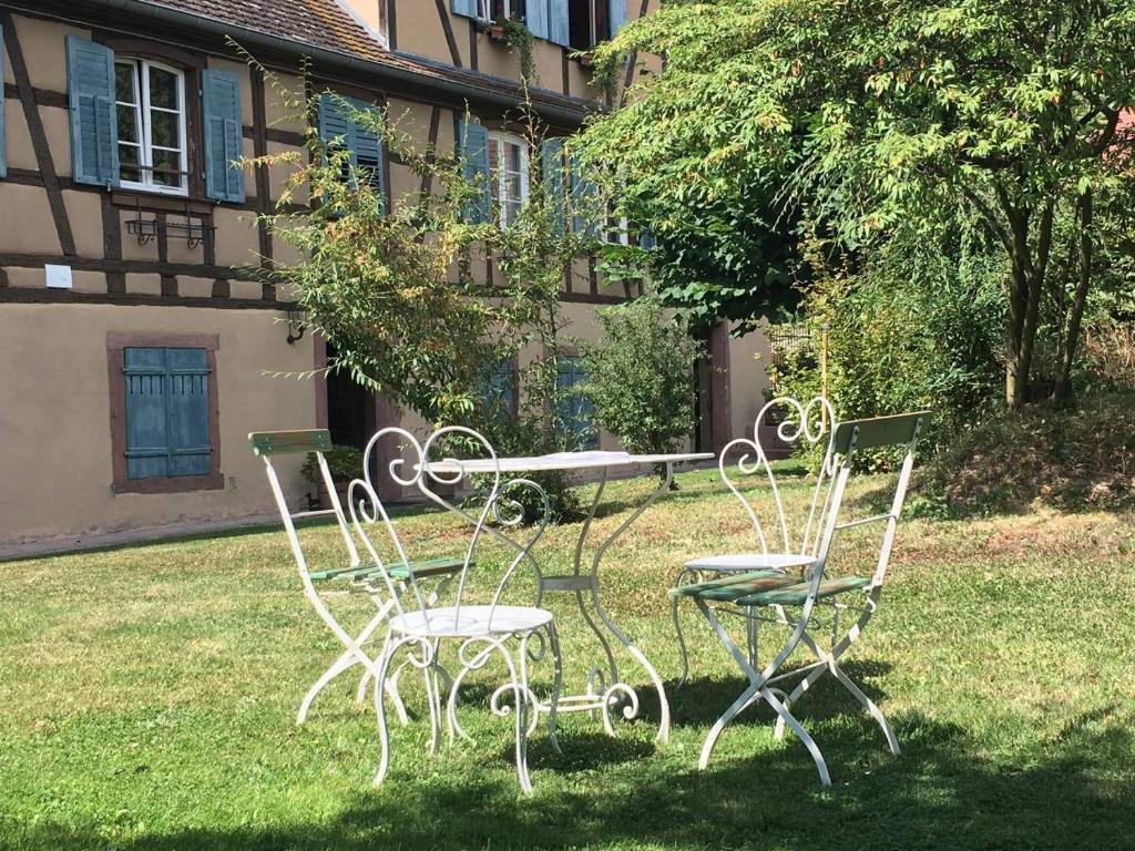 a group of chairs and a table in the grass at Le Gîte du Moulin in Ribeauvillé