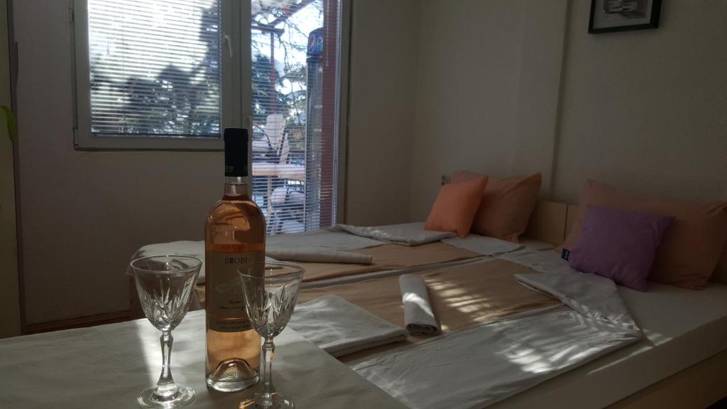 a bottle of wine sitting on a table with two glasses at Vila Dule in Ohrid