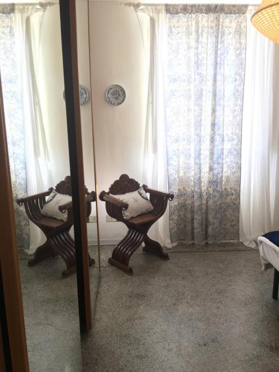 een spiegel met een reflectie van een stoel in een kamer bij Villa Vittoria in Marina di Pietrasanta