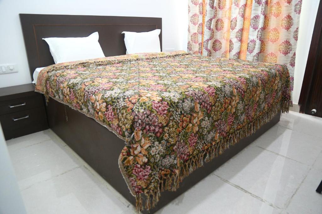 a bedroom with a bed with a flowered blanket on it at Aradhana's Home Stay in Agra