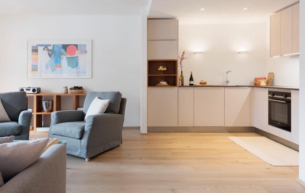 a living room with a couch and a kitchen at Haus-Ascot-Zermatt in Zermatt