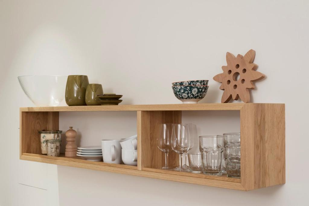 a wooden shelf with dishes and glasses on it at Haus-Ascot-Zermatt in Zermatt