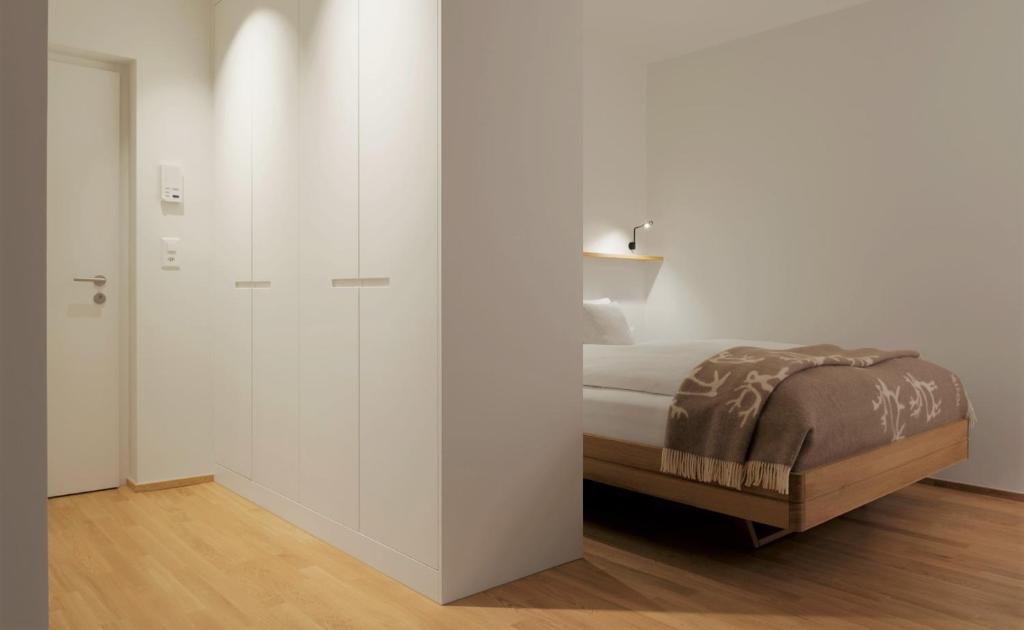 a white bedroom with a bed and a closet at Haus-Ascot-Zermatt in Zermatt