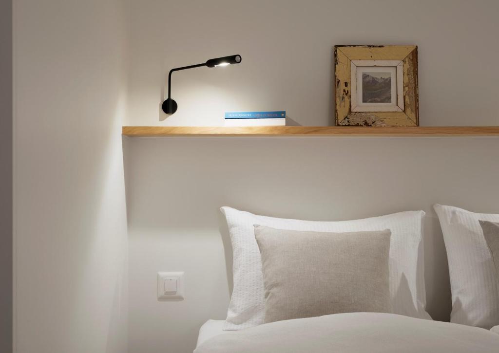 a bedroom with a white bed with a lamp on it at Haus-Ascot-Zermatt in Zermatt