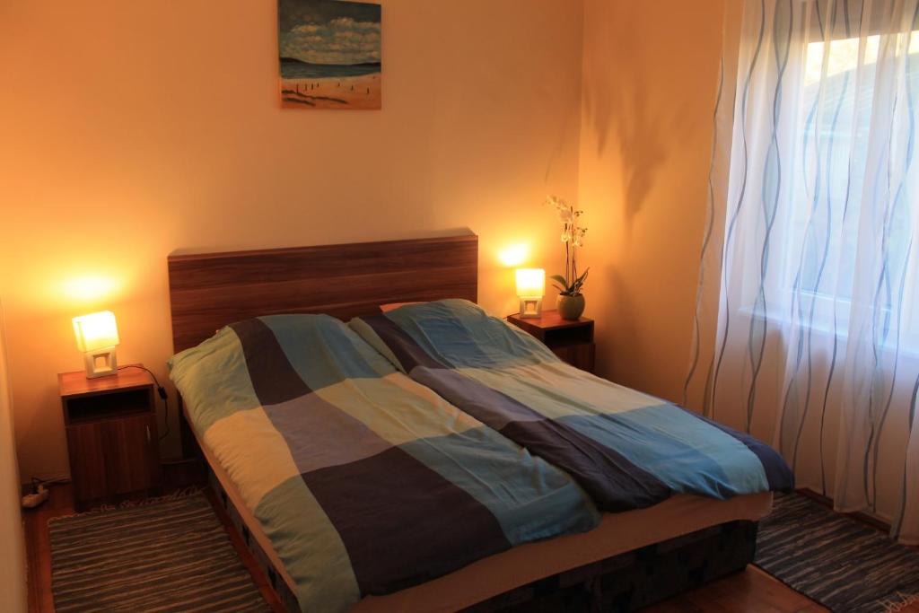 1 dormitorio con 1 cama con 2 lámparas en 2 mesas en Sövényes Szálláshely en Barcs