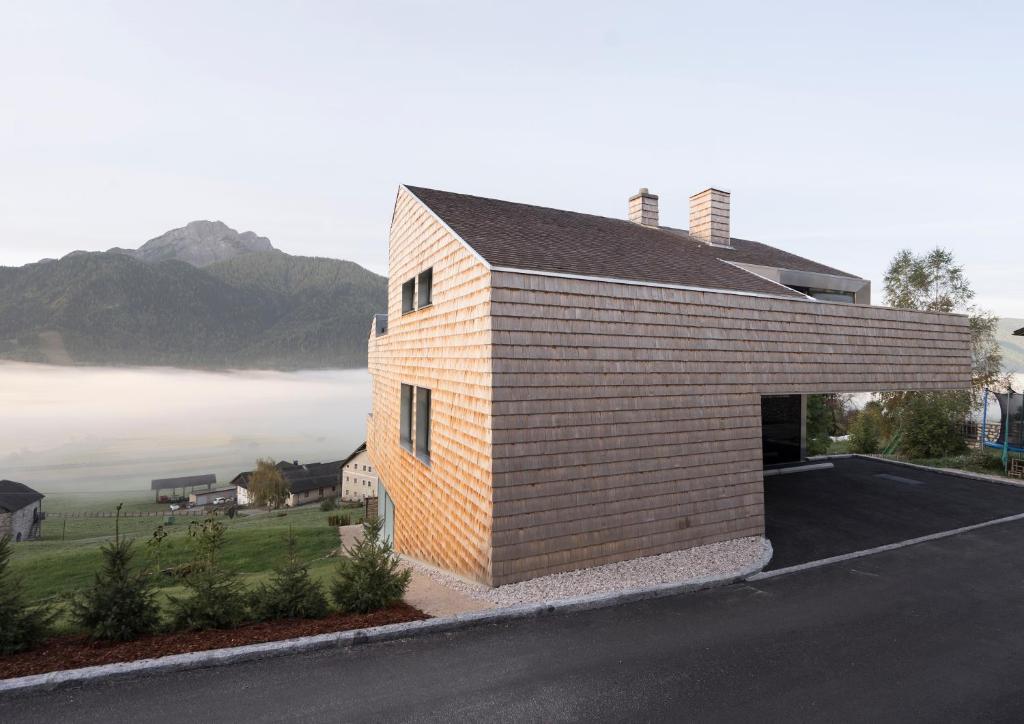 a brick house with a garage on the side of a road at Appartement Hell in Dobbiaco