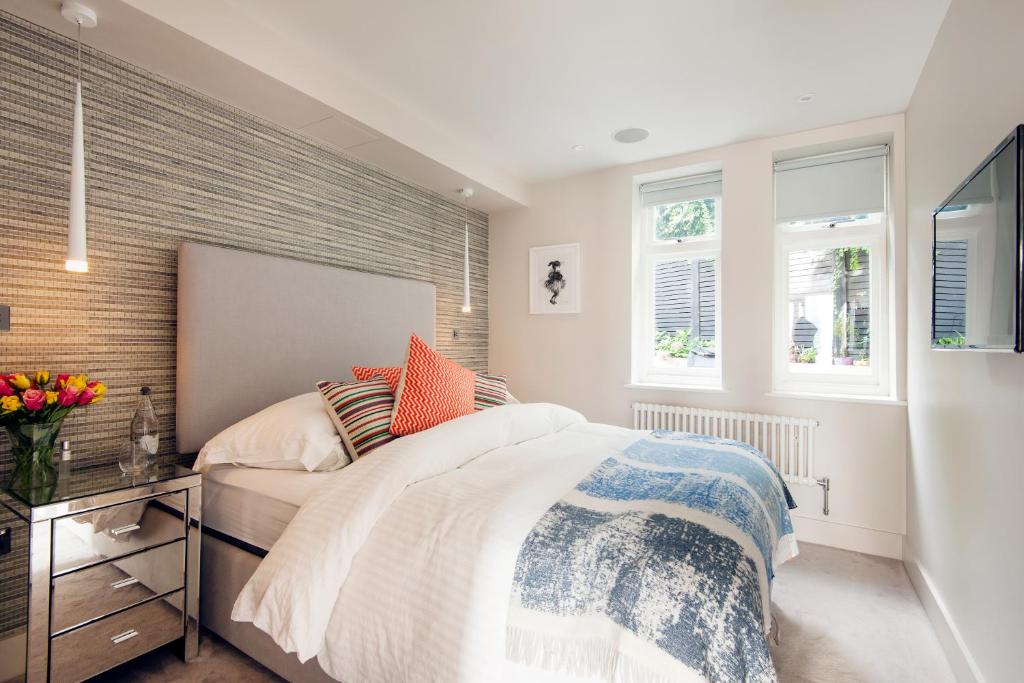 Sleek Arty Apartment في لندن: غرفة نوم بسرير كبير ونوافذ
