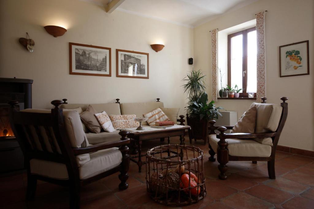 ein Wohnzimmer mit einem Sofa und 2 Stühlen in der Unterkunft Agriturismo Valpietro in Urbania