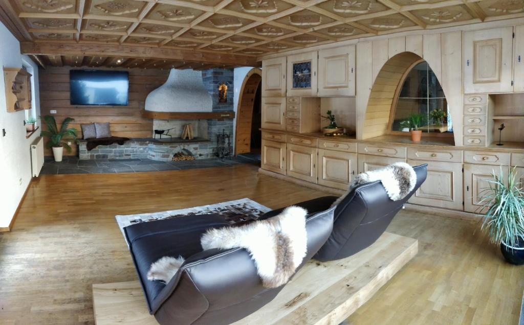 sala de estar con sofá de cuero y chimenea en Apartments Suggadin, en Sankt Gallenkirch