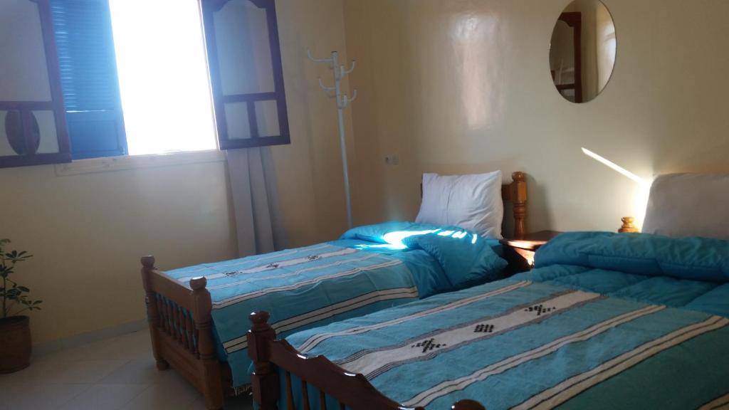 - une chambre avec 2 lits jumeaux et un miroir dans l'établissement Blue Waves apartment, à Agadir