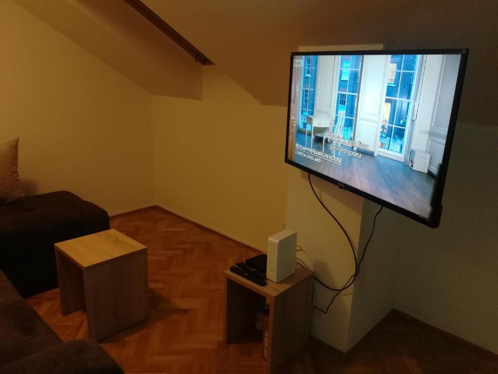 een woonkamer met een flatscreen-tv aan de muur bij Ibis Apartment in Novi Sad