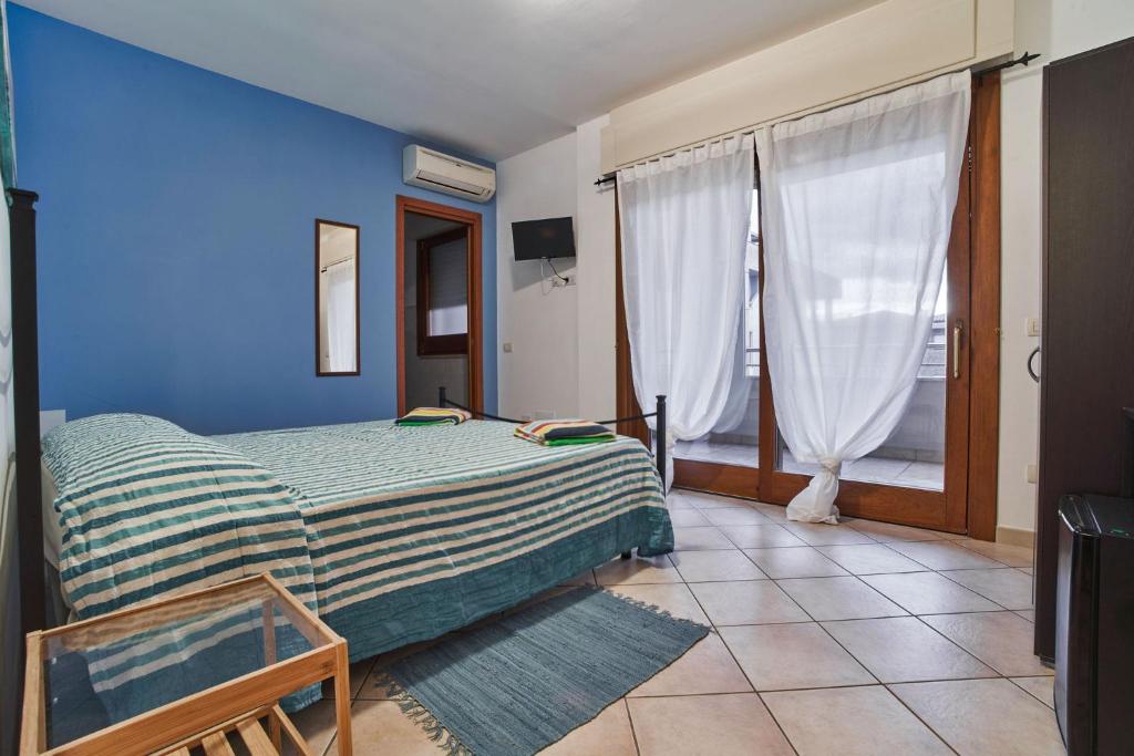 1 dormitorio con cama y pared azul en Arcibaleno en Sabaudia