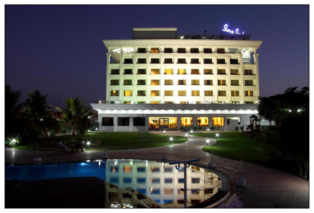 un edificio con una piscina delante de él por la noche en Sun-n-Sand Shirdi, en Shirdi