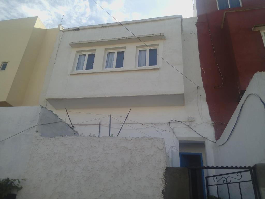 a white building with blue windows on the side of it at Maison traditionnelle marocaine in Rabat