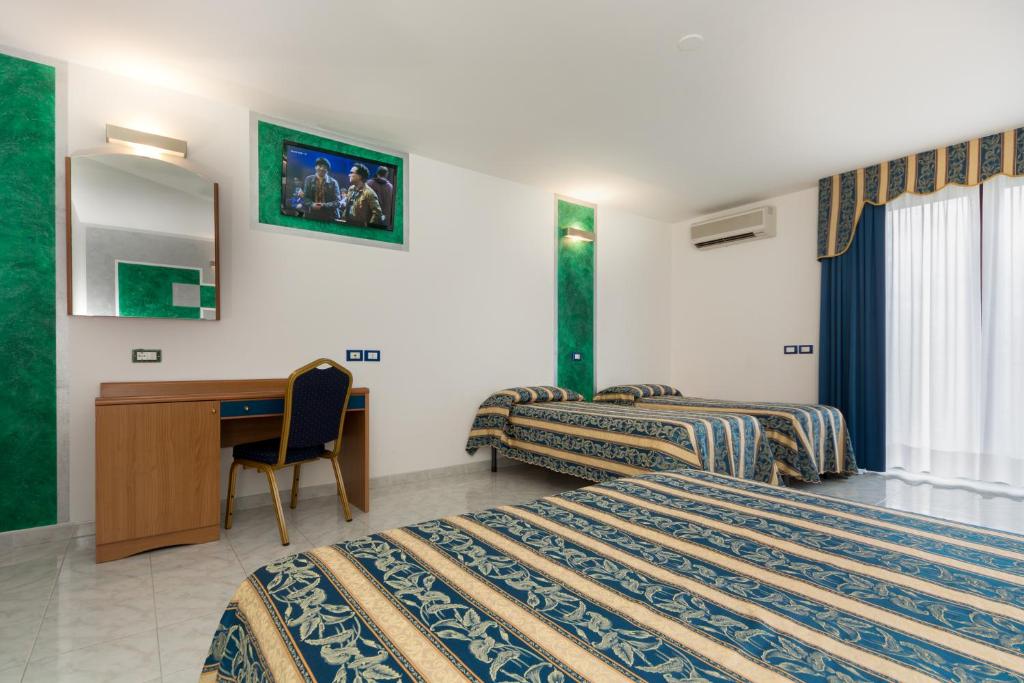 Pokój hotelowy z 2 łóżkami i biurkiem w obiekcie Hotel Centrale w mieście Latisana