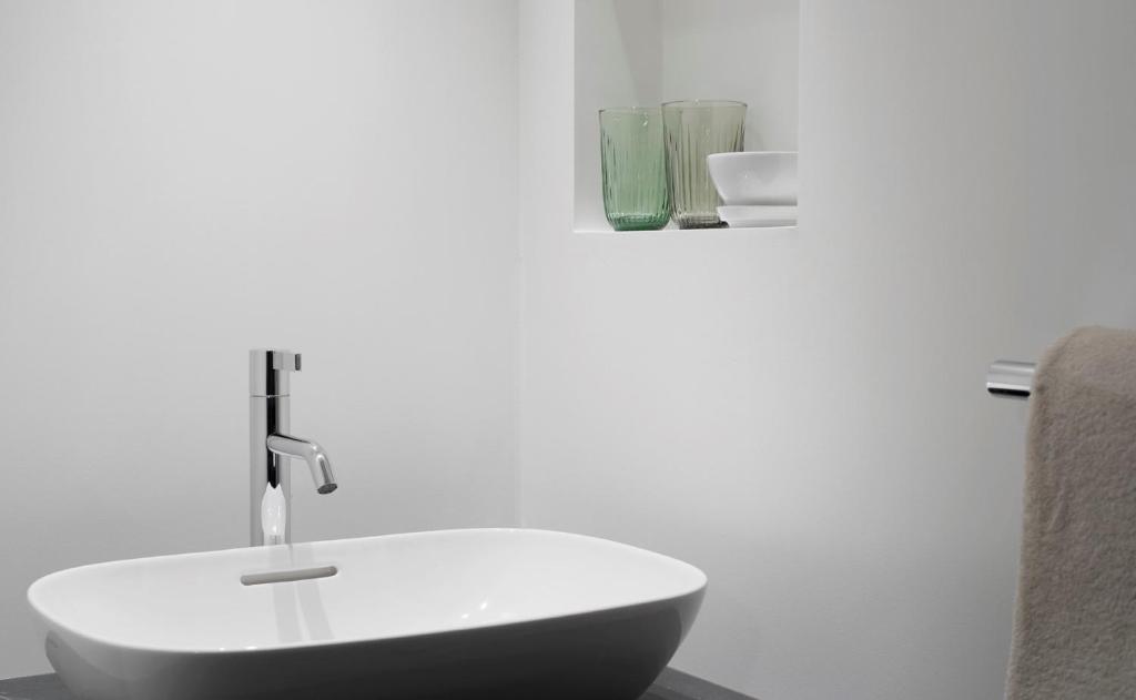 a bathroom with a white sink and a chair at Haus-Ascot-Zermatt in Zermatt