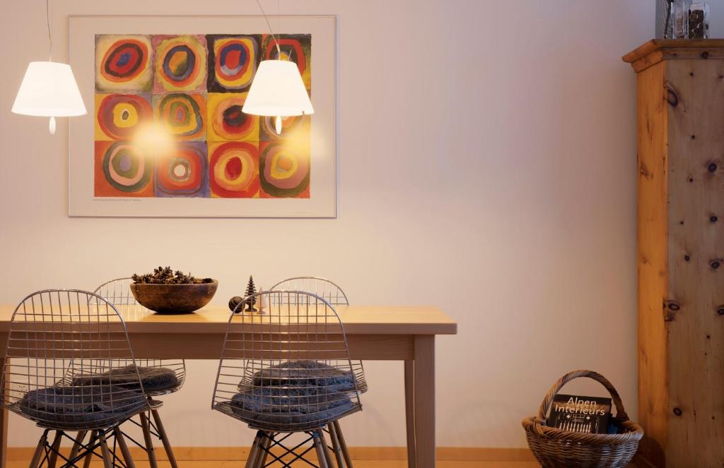 a dining room table with two chairs and a painting at Haus-Ascot-Zermatt in Zermatt